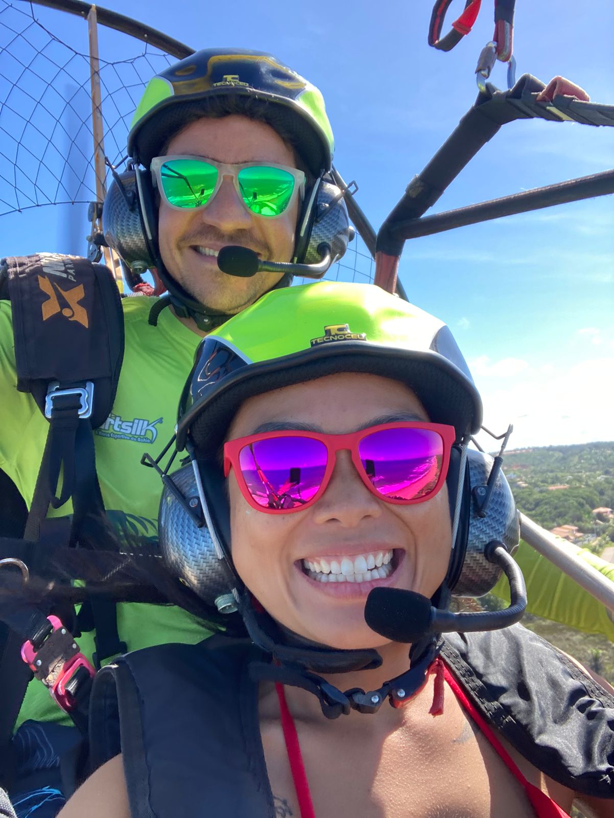 Voo duplo de paramotor — piloto e passageira sorrindo