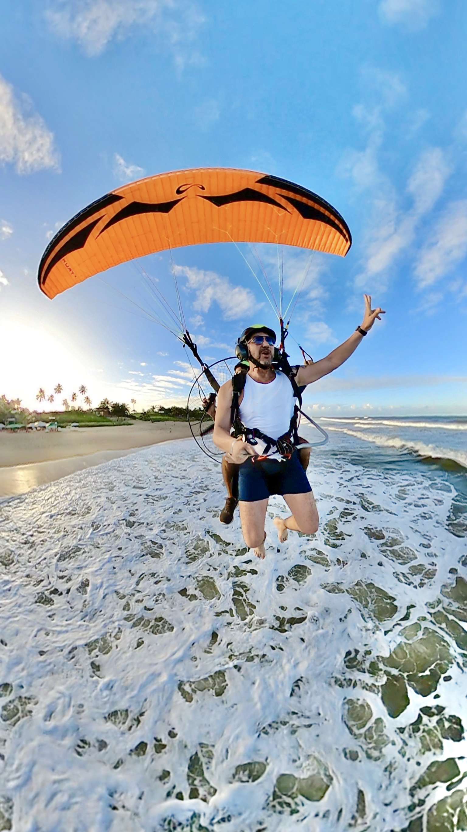 Voo duplo de paramotor — piloto e passageira sorrindo